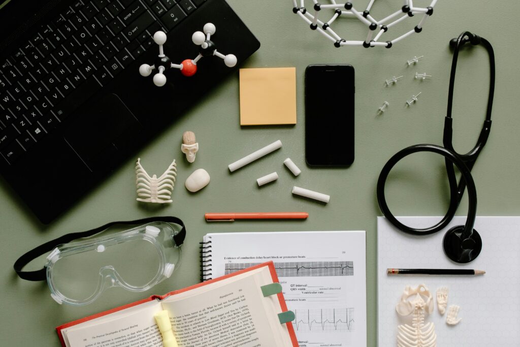 Flat lay of medical tools, journal, and study materials in a lab setting.